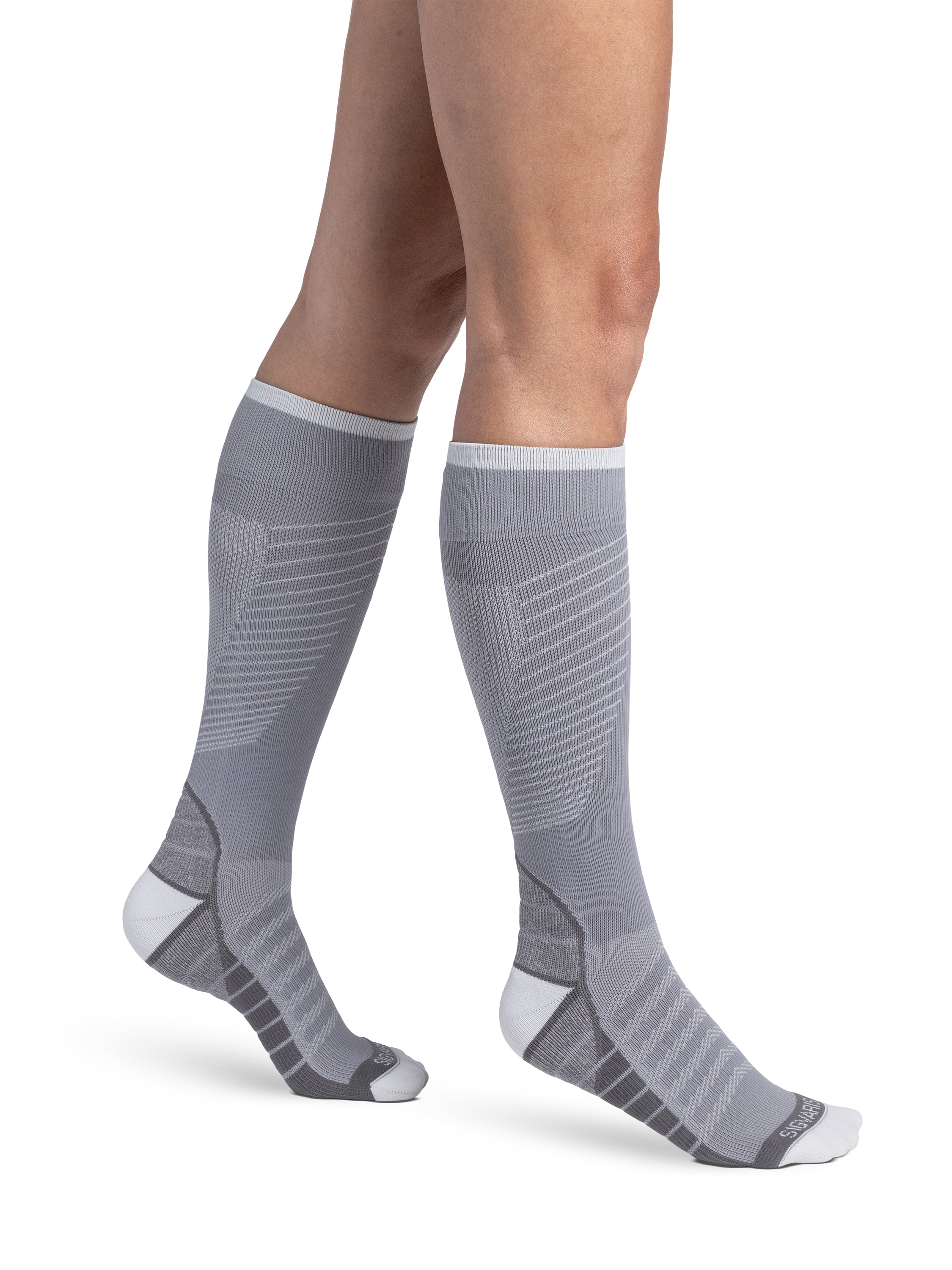 Woman wearing Sigvaris Motion Flow Tech compression socks in the color Cool Grey