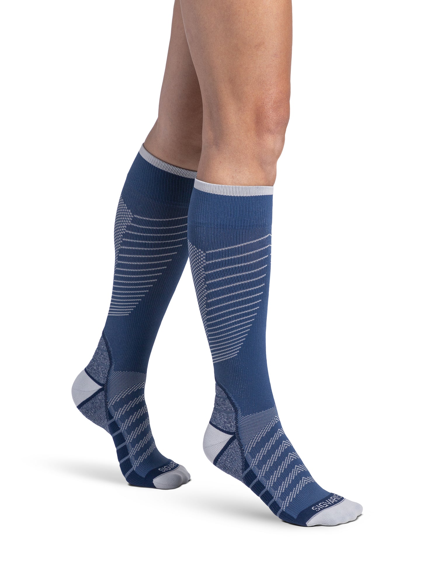 Woman wearing Sigvaris Motion Flow Tech compression socks in the color Deep Sea