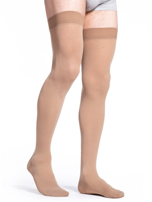 Man wearing Sigvaris Essential Cotton compression thigh-highs in the color Light Beige