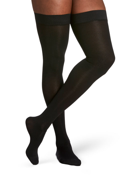 Man wearing Sigvaris Essential Cotton compression thigh-highs in the color Black