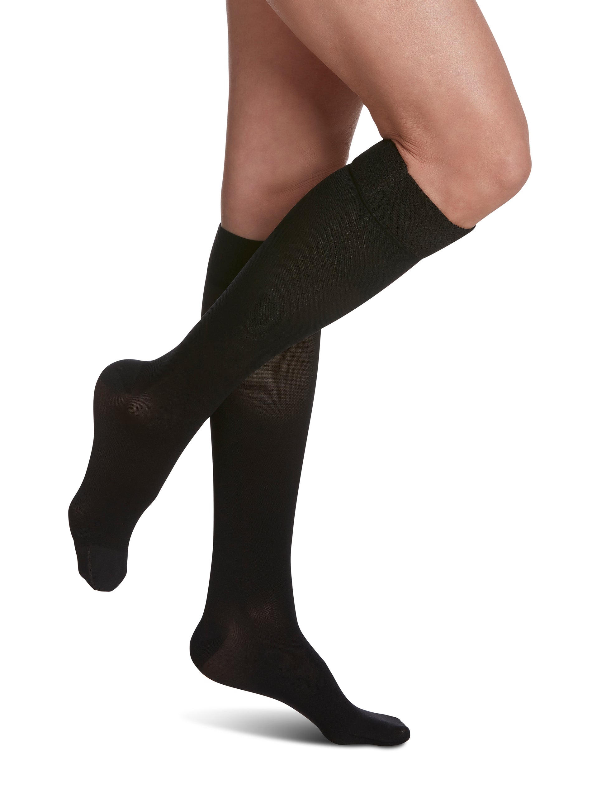 Woman wearing Sigvaris Essential Opaque compression grip-top knee-highs in the color Black