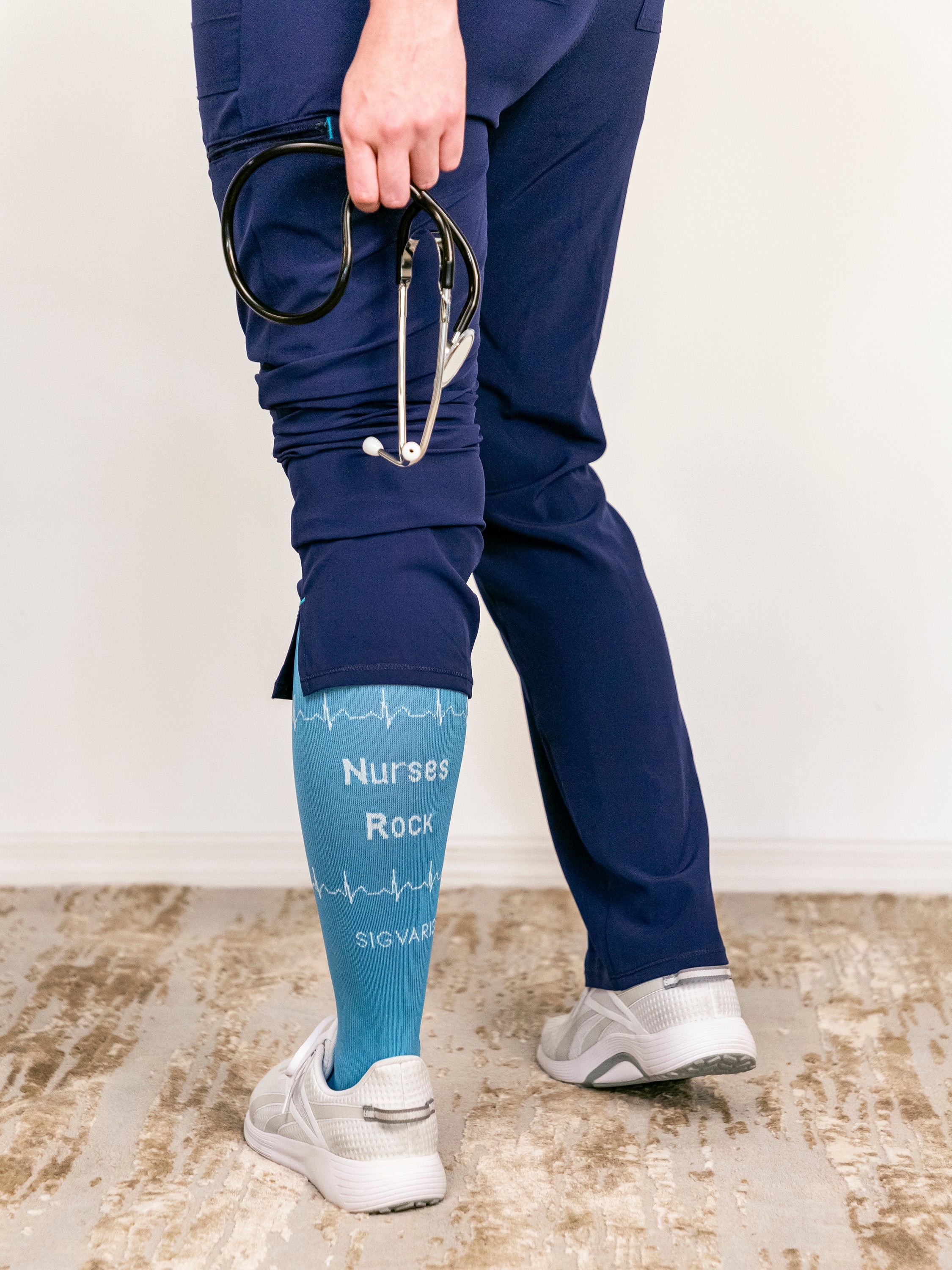 Nurse standing to show the back of SIGVARIS GROUP Microfiber Shades compression socks in the color Nurse Blue