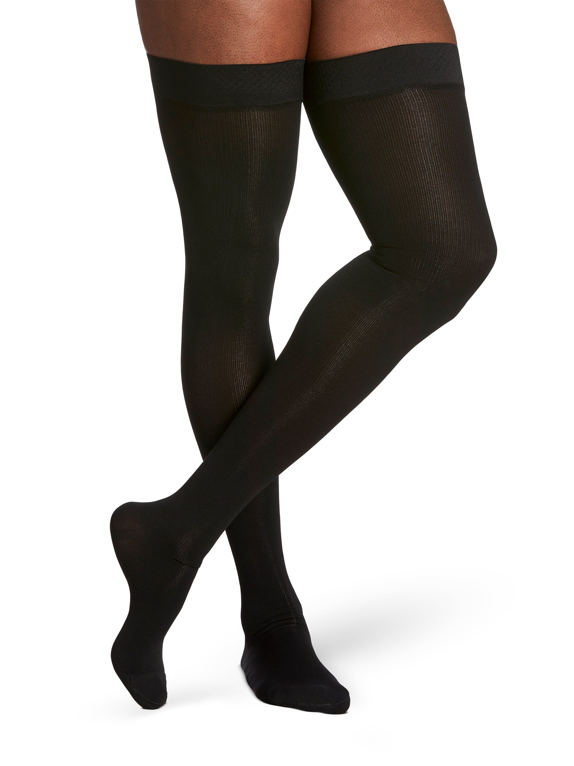 Man wearing Sigvaris Essential Cotton compression thigh-highs in the color Black