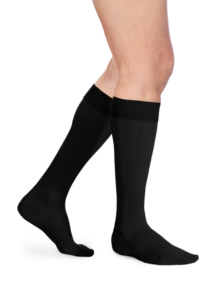 Man wearing Sigvaris Essential Opaque calf plus with grip-top in the color Black