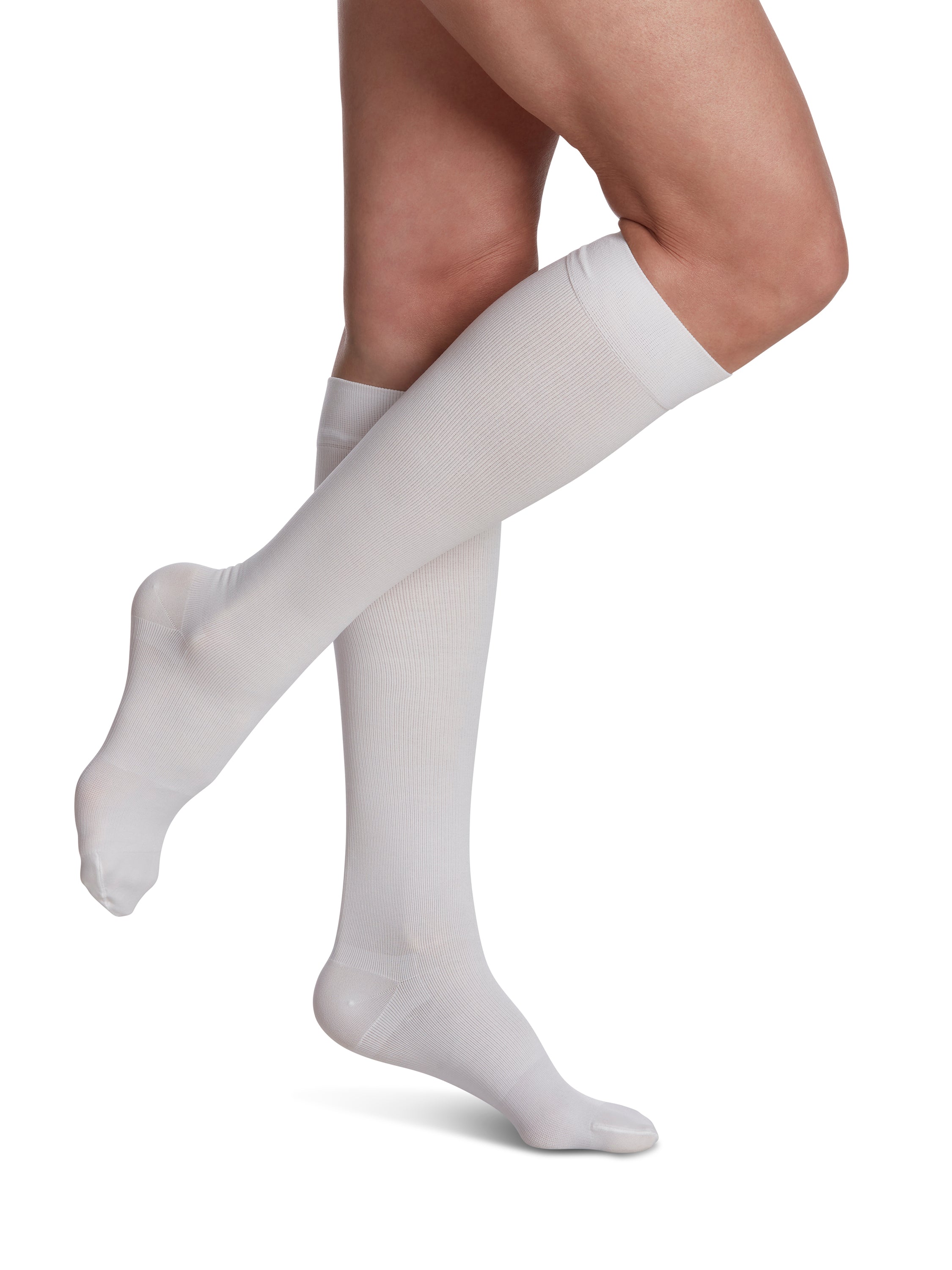 Woman wearing Sigvaris Essential Cotton compression knee-highs in the color White