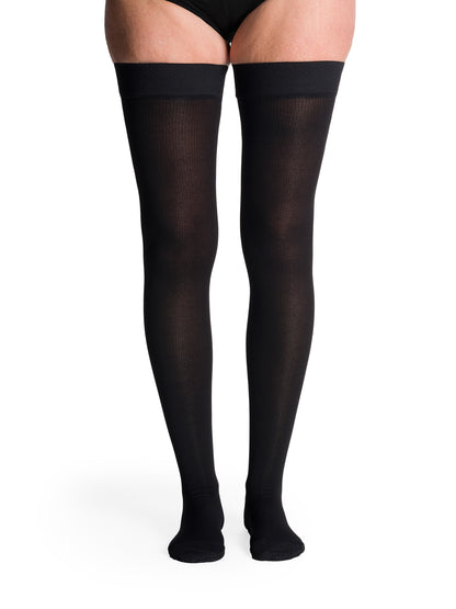 Woman wearing Sigvaris Essential Cotton compression thigh-highs in the color Black