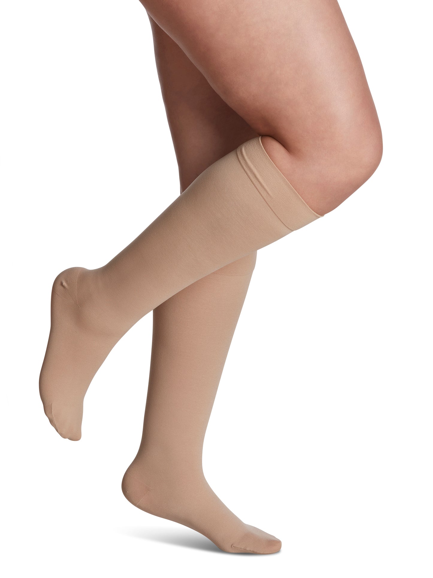 Woman wearing Sigvaris Essential Opaque compression knee-highs in the color Honey